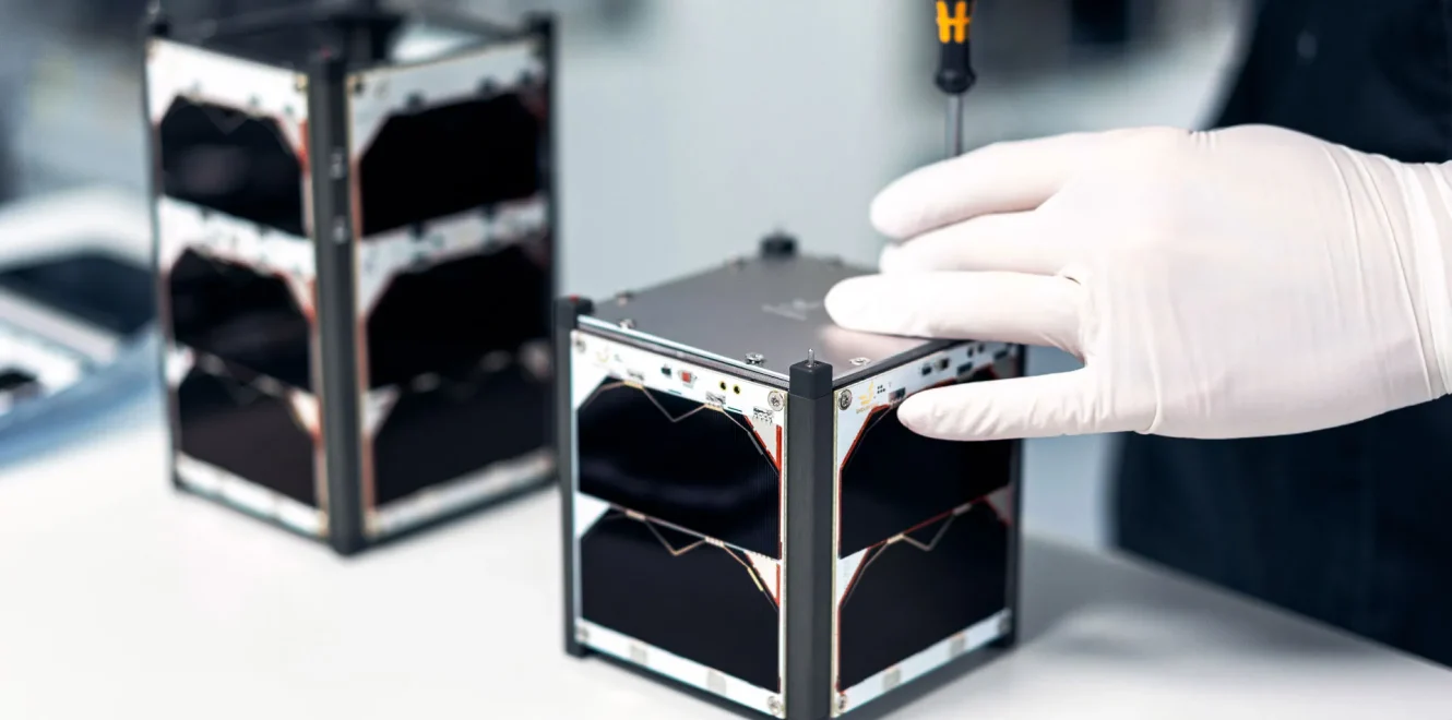 A side view of a technician attaching 1U Solar Panels on a EnduroSat 1U CubeSat nanosatellite.