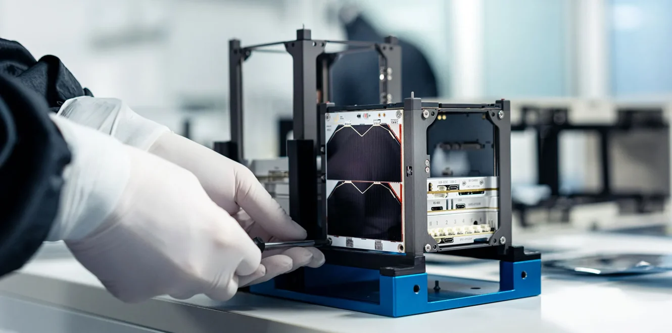 A closeup side shot of a technician attaching the 1U Solar Panel X/Y onto the EnduroSat 1U CubeSat nanosatellite.